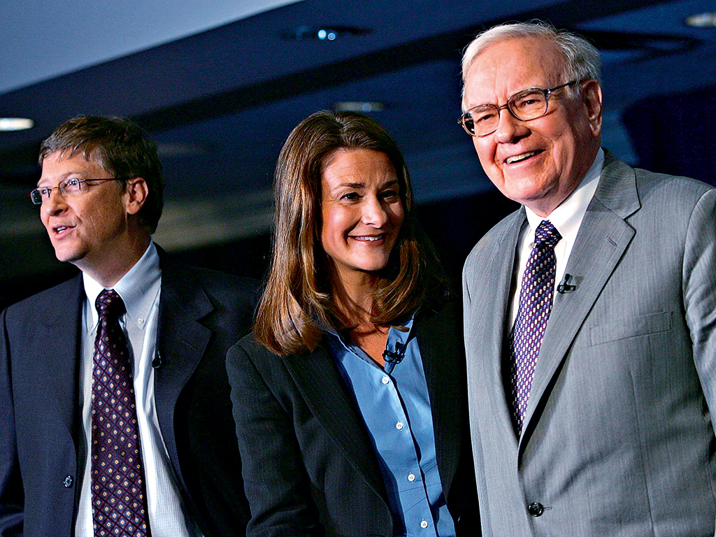 Warren Buffett (r) stands with Bill and Melinda Gates at a news conference where Buffett spoke about his financial gift to the Bill & Melinda Gates Foundation