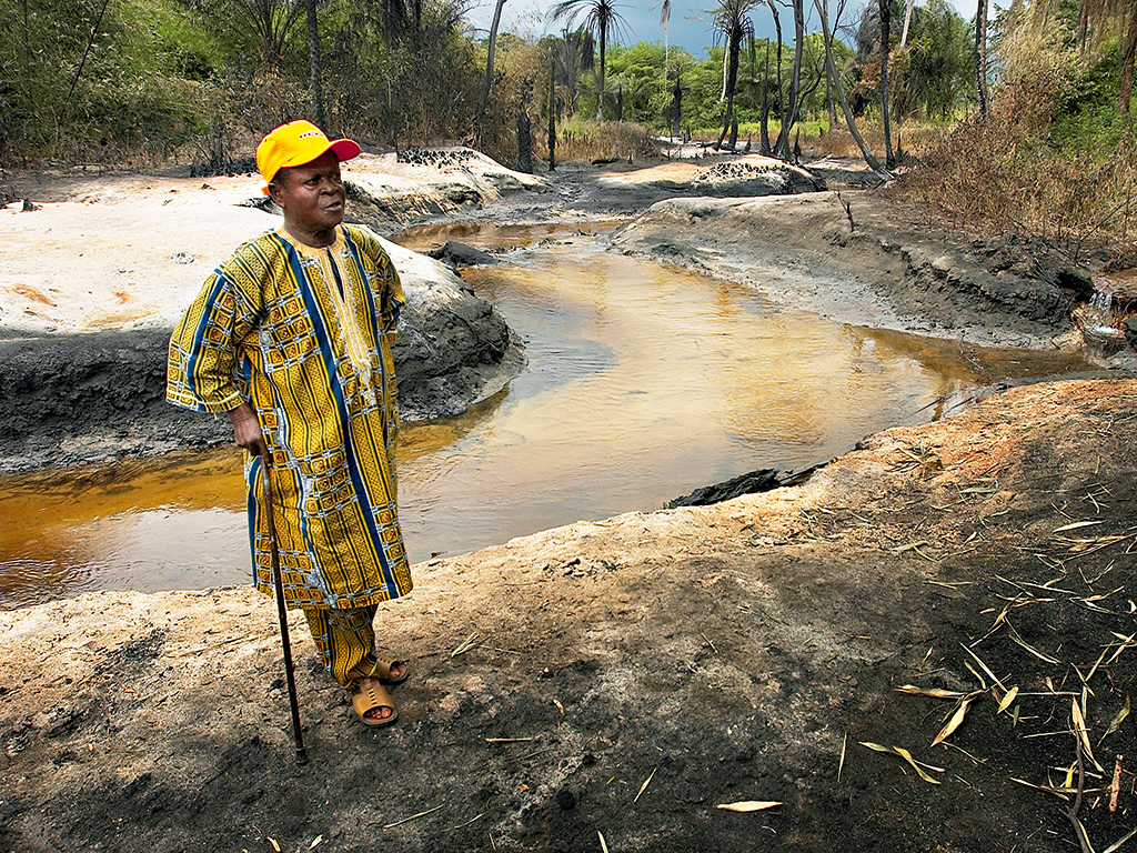 A Nigerian village chief looks at the site of a crude oil fire. Though rich in oil, Nigeria sits low on the Corruption Perceptions Index