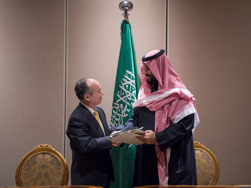 Masayoshi Son, CEO of SoftBank and Crown Prince of Saudi Arabia Mohammed bin Salman shake hands after signing solar power project agreement